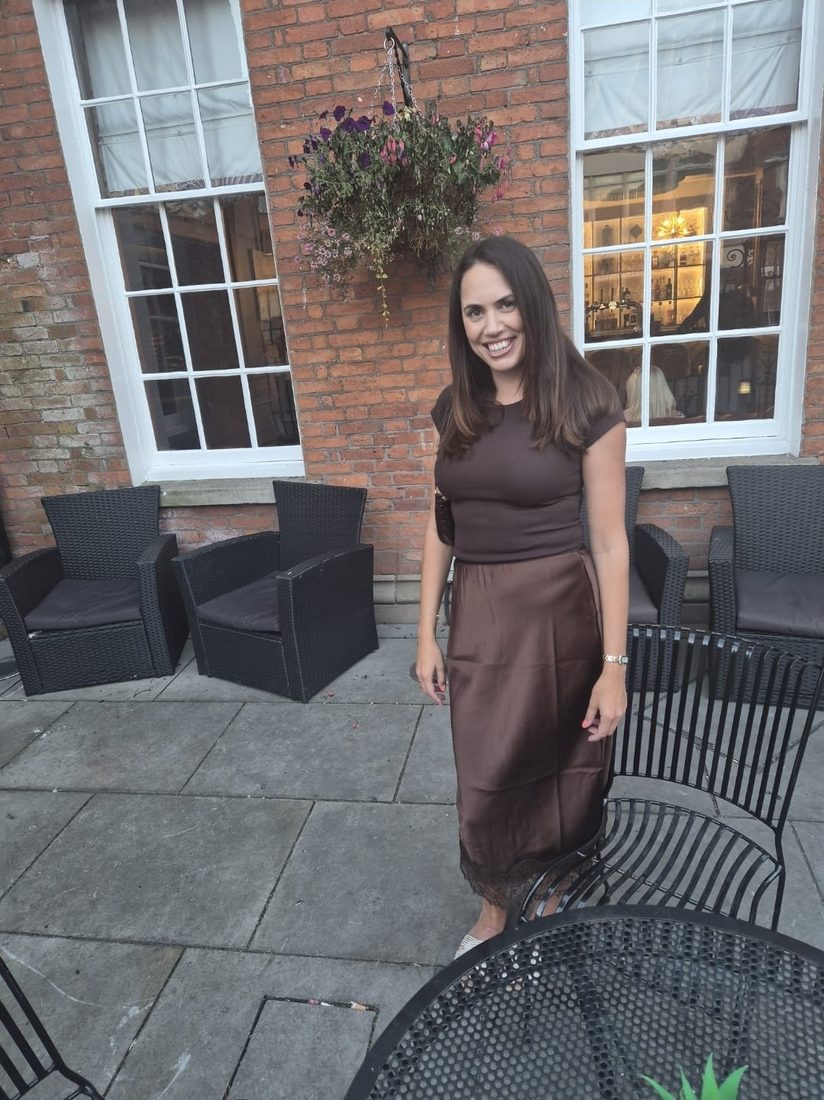 Natasha Joy Brady smiling outside a red brick building