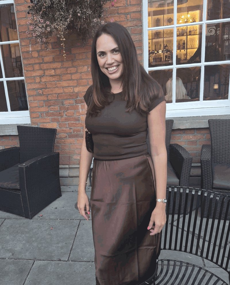 Natasha Joy Brady smiling outside a red brick building