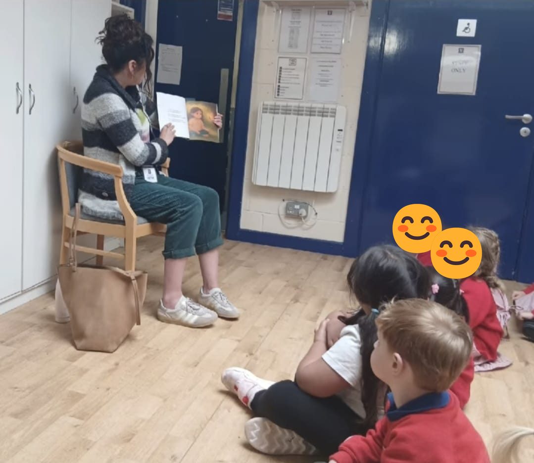 Natasha reading The Sparkling Leaf to a class of children sitting on the floor